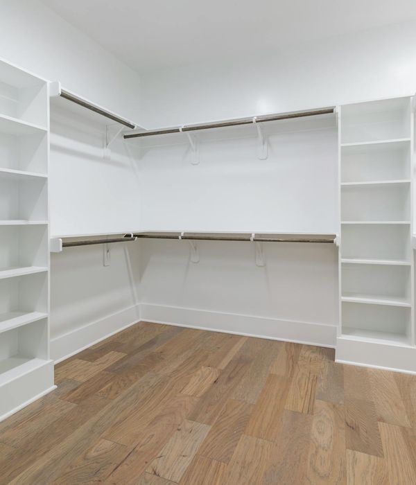 Organized walk-in closet with custom shelving and ambient lighting